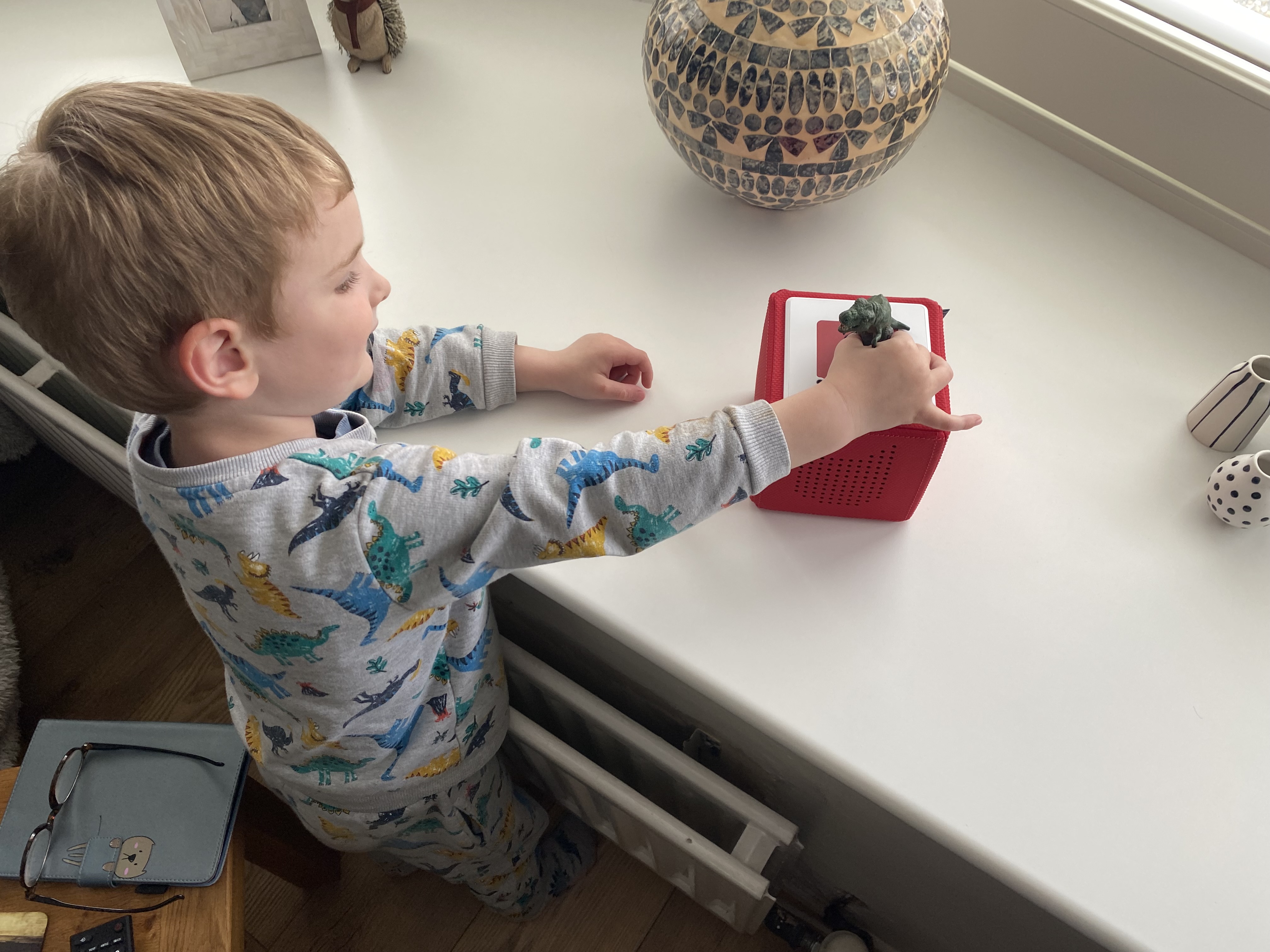 Four year old placing a Tonie character on top of the Toniebox
